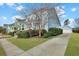 A charming two-story home with a lush front lawn, mature tree, and a long driveway leading to a detached garage at 3676 Shutesbury St, Mount Pleasant, SC 29466
