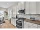 Well-lit kitchen with stainless steel appliances, white cabinets, granite countertops, and hardwood floors at 3676 Shutesbury St, Mount Pleasant, SC 29466