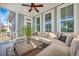 A cozy sunroom features a ceiling fan, large windows, and comfortable seating with a wicker coffee table and decorative plant at 3676 Shutesbury St, Mount Pleasant, SC 29466