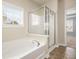 This bright bathroom has a tub and separate glass shower with a tan tile floor at 406 Butterfly Bush Dr, Goose Creek, SC 29445