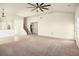 Spacious living room features neutral decor, a ceiling fan, stairs, and an open layout to the dining area at 406 Butterfly Bush Dr, Goose Creek, SC 29445