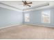 This bedroom features a ceiling fan, tray ceiling, carpeted floor, and two windows at 406 Butterfly Bush Dr, Goose Creek, SC 29445
