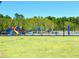 Colorful community playground area with swings, slides, picnic tables and a secure perimeter fence at 406 Butterfly Bush Dr, Goose Creek, SC 29445