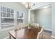 Bright dining area featuring a dark-stained wood table, decorative chandelier, and natural light from large windows at 464 Fox Sparrow Ct, Summerville, SC 29486