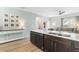 Kitchen island with stainless steel sink, dark cabinetry and open floorplan view into living area at 464 Fox Sparrow Ct, Summerville, SC 29486