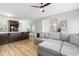 Open concept living room with gray couch, ceiling fan and kitchen with dark cabinetry and stainless appliances at 464 Fox Sparrow Ct, Summerville, SC 29486