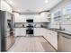 Modern kitchen with stainless steel appliances, white cabinets, granite countertops, and light wood floors at 5034 Pittman St, North Charleston, SC 29405