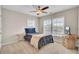 Bedroom with a ceiling fan, carpet, a bed with a blue quilt, a side table, and three bright windows at 518 Mountain Laurel Cir, Goose Creek, SC 29445