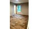 Bedroom with light-tone walls, wood-look floors, window with view, and an open doorway at 5355 Old Military Rd, Adams Run, SC 29426