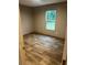 Bedroom with light-tone walls, wood-look floors, window with view, and an interior door at 5355 Old Military Rd, Adams Run, SC 29426