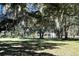 Single-story home with a well-manicured lawn and mature trees with Spanish moss at 5355 Old Military Rd, Adams Run, SC 29426