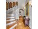 Elegant entryway featuring a curved staircase, wood floors, decorative wall art, and stylish console table at 54 Gibbes St, Charleston, SC 29401