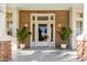 Beautiful front entrance with a white door, brick accents, elegant lighting, and lush potted plants adding curb appeal at 54 Gibbes St, Charleston, SC 29401