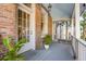 A charming brick porch features a white door, lantern lighting, and greenery, creating a welcoming outdoor space at 54 Gibbes St, Charleston, SC 29401