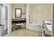 Bathroom boasts vanity area, framed mirror and soaking tub, offering a luxurious spa-like retreat with refined decor at 5802 Palmetto Dr # B-202, Isle of Palms, SC 29451