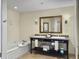 Well-lit bathroom features a double granite vanity, a framed mirror, and a soaking tub, combining style and comfort at 5802 Palmetto Dr # B-202, Isle of Palms, SC 29451