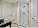 Bathroom featuring glass enclosed shower, tile surround, granite countertop, and white doors, combining style and comfort at 5802 Palmetto Dr # B-202, Isle of Palms, SC 29451