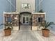 Welcoming entrance with brick accents, potted plants, and modern lighting, offers access to Elevator B at 5802 Palmetto Dr # B-202, Isle of Palms, SC 29451