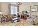 Cozy living room featuring neutral colors, wood floors, comfortable seating, and natural lighting at 5802 Palmetto Dr # B-202, Isle of Palms, SC 29451