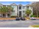 Three-story condominium building with palm trees, stairs, and parking at 700 Daniel Ellis Dr # 14206, Charleston, SC 29412