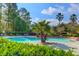 Sparkling community pool featuring lounge chairs, lush greenery, and towering palm trees under a sunny blue sky at 700 Daniel Ellis Dr # 14206, Charleston, SC 29412