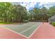 Outdoor tennis court featuring a green and red surface with trees and fencing in the background on a sunny day at 700 Daniel Ellis Dr # 14206, Charleston, SC 29412
