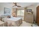 Tranquil bedroom with a queen bed, ceiling fan, and natural light from a window and curtains at 7000 Palmetto Dr # 5A, Isle of Palms, SC 29451