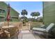 Relaxing deck with wood table and chairs, a lounger, and scenic views of palm trees and other condos at 7000 Palmetto Dr # 5A, Isle of Palms, SC 29451