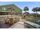 Outdoor deck with a dining table, seating, and a serene view of the surrounding landscape at 7000 Palmetto Dr # 5A, Isle of Palms, SC 29451