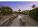 Community landscape path with wooden retaining walls and lush greenery at dusk under a bright sky at 7000 Palmetto Dr # 5A, Isle of Palms, SC 29451