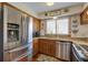 Bright kitchen featuring stainless steel appliances, wooden cabinets, and granite countertops under warm lighting at 7000 Palmetto Dr # 5A, Isle of Palms, SC 29451