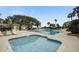 Community pool area with lounge chairs, palm trees, and well-manicured landscaping at 7000 Palmetto Dr # 5A, Isle of Palms, SC 29451