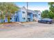 Two-story light blue condo building with a gravel parking area and dark blue SUV at 851 Sandlake Dr # F, Mount Pleasant, SC 29464