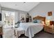 Bright main bedroom with balcony, large bed, ensuite, and vaulted ceilings at 851 Sandlake Dr # F, Mount Pleasant, SC 29464