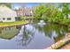 Picturesque pond with fountain surrounded by lush landscaping and neighborhood buildings in the background at 851 Sandlake Dr # F, Mount Pleasant, SC 29464