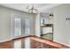 The dining room with wood floors features a modern chandelier and access to the kitchen and the back patio at 105 Alan Ct, Summerville, SC 29485