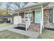 A charming brick home showcases a cozy front porch with white railings and a bright blue front door at 105 Alan Ct, Summerville, SC 29485