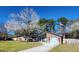 Cozy one-story home with brick accents, lush green lawn, flowering tree, and American flag at 105 Ford Ct, Summerville, SC 29483