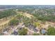 An aerial view shows mature trees surrounding lovely, well-kept houses in a neighborhood with a golf course at 105 Pine Valley Dr, Summerville, SC 29483