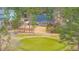 Aerial view of lush golf course and charming brick home surrounded by tall pine trees and manicured lawns at 105 Pine Valley Dr, Summerville, SC 29483