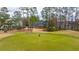 The back exterior of this home has a well-manicured lawn, golf course views, and ample space for outdoor activities at 105 Pine Valley Dr, Summerville, SC 29483