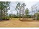 Expansive backyard featuring mature trees, well-maintained lawn, and views of the adjacent golf course at 105 Pine Valley Dr, Summerville, SC 29483
