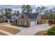 The exterior of this brick home boasts a two-car garage, a circular driveway, and carefully designed landscaping at 105 Pine Valley Dr, Summerville, SC 29483