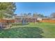 Spacious backyard with a lush green lawn, wooden fence, picnic table, and trampoline for active outdoor fun at 114 Merrimack Blvd, Moncks Corner, SC 29461