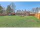 Expansive backyard with a well-maintained lawn, wooden fence, picnic table, and trampoline for outdoor enjoyment at 114 Merrimack Blvd, Moncks Corner, SC 29461