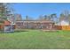 Well-kept backyard with a green lawn, brick home, a wooden fence, and picnic table for enjoying outdoor living at 114 Merrimack Blvd, Moncks Corner, SC 29461