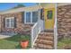 Inviting front entrance with a vibrant yellow door, brick steps, and manicured flower pots at 114 Merrimack Blvd, Moncks Corner, SC 29461