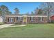 Charming brick home with a well-manicured lawn, complemented by a bright yellow front door at 114 Merrimack Blvd, Moncks Corner, SC 29461