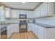 Galley kitchen with granite countertops, white cabinets, stainless steel appliances, and hardwood floors at 114 Merrimack Blvd, Moncks Corner, SC 29461