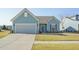Charming single-story home with blue siding, well-manicured lawn, and a two-car garage on a sunny day at 127 Garden Gate Way, Summerville, SC 29486